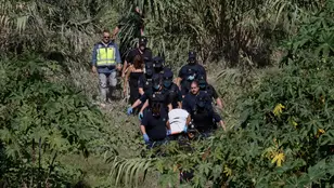 Miembros del retén fúnebre y agentes de la Policía Nacional trasladan el cadáver del hombre que fue arrastrado hace justo una semana por el agua.