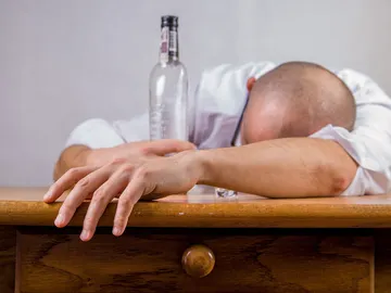 Fotografía de un hombre que se ha quedado dormido tras beber alcohol. Fotografía de un hombre que se ha quedado dormido tras beber alcohol.
