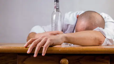 Fotografía de un hombre que se ha quedado dormido tras beber alcohol. Fotografía de un hombre que se ha quedado dormido tras beber alcohol.
