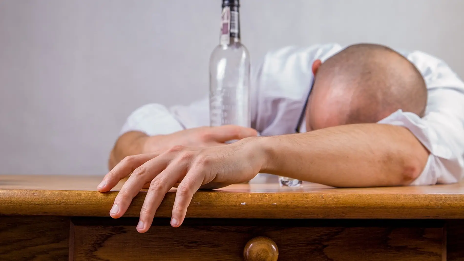 Fotografía de un hombre que se ha quedado dormido tras beber alcohol. Fotografía de un hombre que se ha quedado dormido tras beber alcohol.