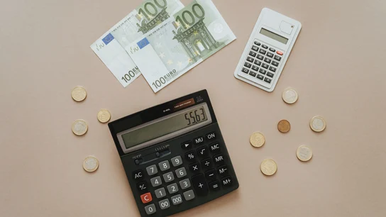Imagen de archivo de dinero y una calculadora Imagen de archivo de dinero y una calculadora