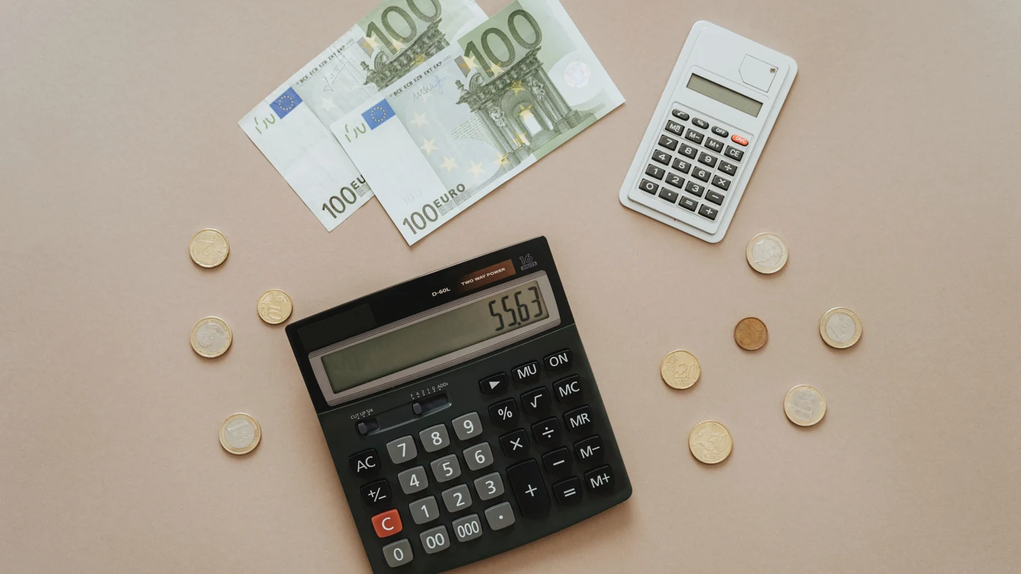 Imagen de archivo de dinero y una calculadora Imagen de archivo de dinero y una calculadora