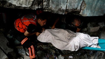 Palestinos buscan víctimas bajo los escombros tras los ataques israelíes, en Khan Younis