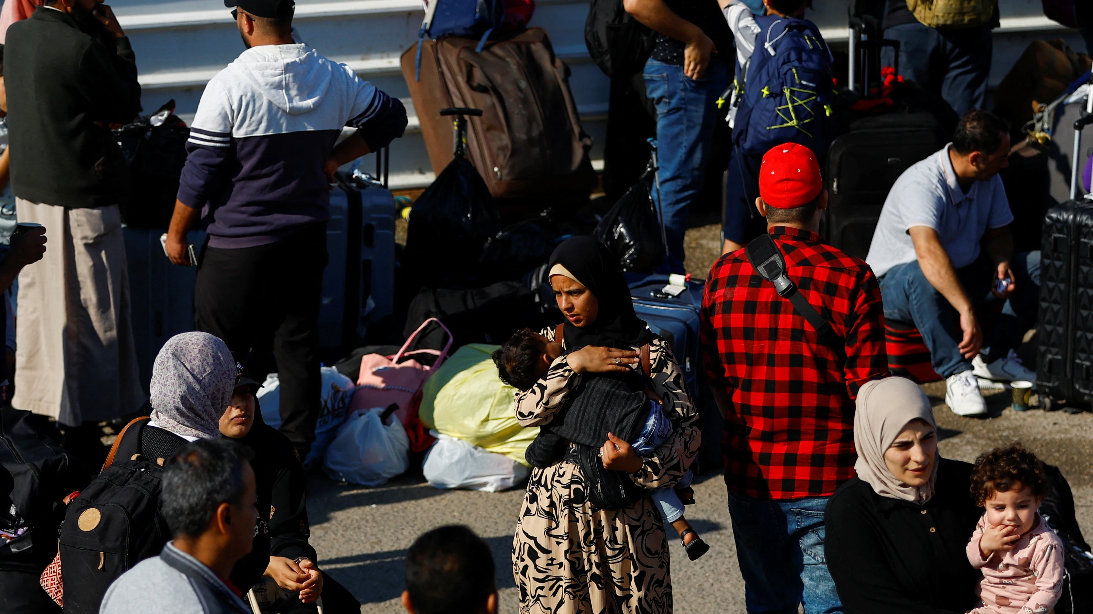 Los palestinos con doble ciudadanía se reúnen fuera del cruce fronterizo de Rafah con Egipto con la esperanza de obtener permiso para salir de Gaza.