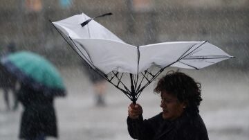 Una mujer con el paraguas dado la vuelta en Santiago