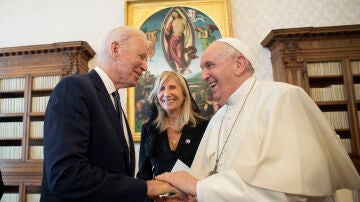 Joe Biden y el papa Francisco se dan la mano durante un encuentro