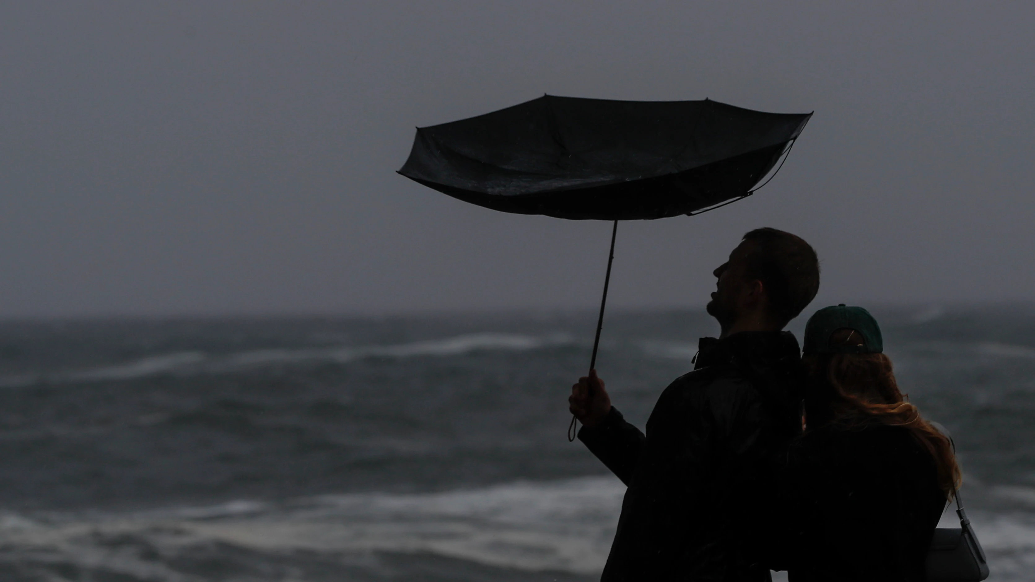 Turistas observan el oleaje rompiendo contra el Paseo Nuevo de San Sebastián