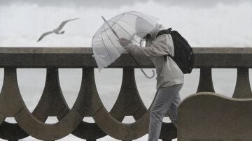 Una persona se protege de la lluvia y el viento con un paraguas en A Coruña.