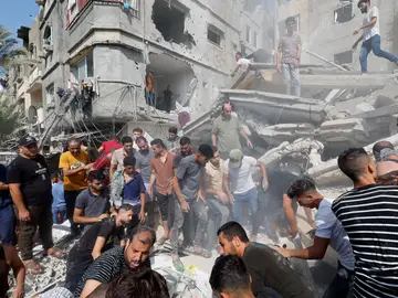 Los palestinos buscan entre los escombros a sus familiares tras los bombardeos israelíes a edificios residenciales en Khan Younis.