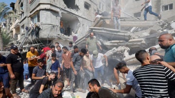 Los palestinos buscan entre los escombros a sus familiares tras los bombardeos israelíes a edificios residenciales en Khan Younis.