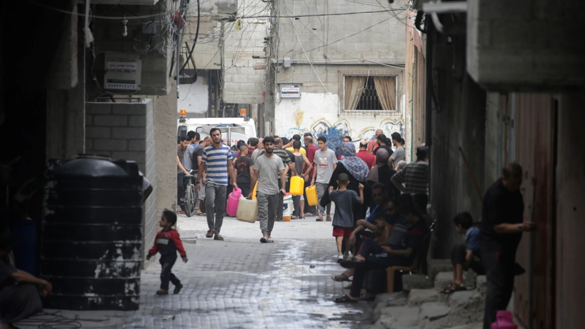 Palestinos hacen cola para llenar sus garrafas de agua en Gaza City