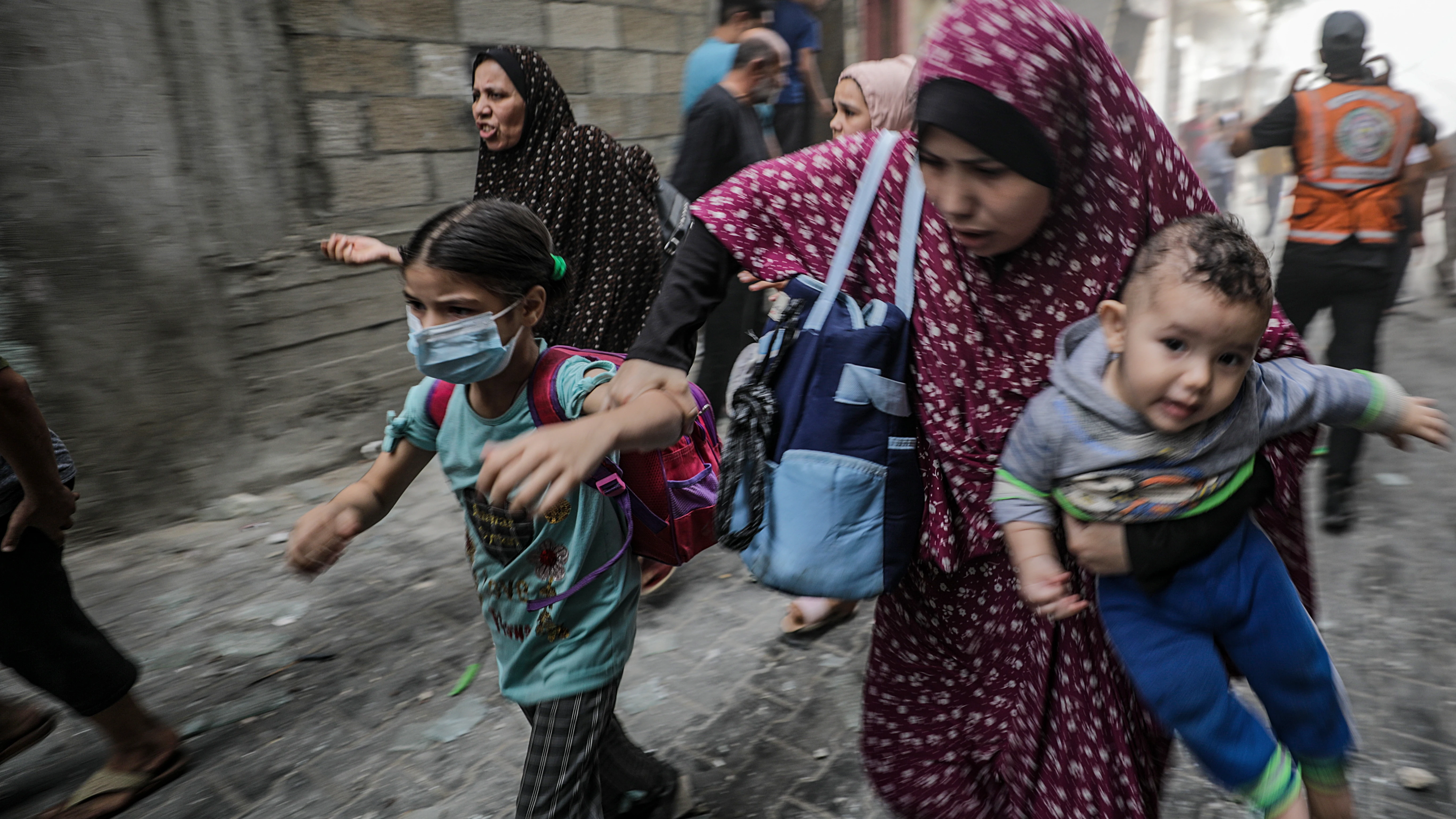 Mujeres y niños palestinos huyen tras un ataque aéreo israelí en la ciudad de Gaza.