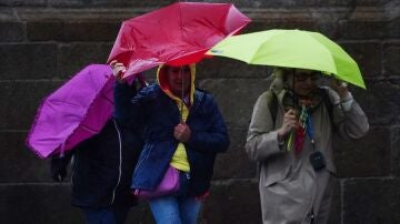 Imagen de archivo. Varias personas con paraguas.