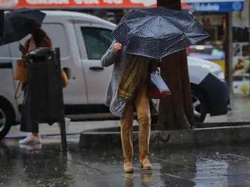 Una persona camina por el centro de la capital en una jornada marcada por las lluvias.