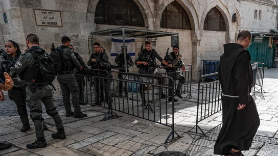 Un fraile franciscano pasa ante un numeroso grupo de Agentes de la Policía de Fronteras israelí Un fraile franciscano pasa ante un numeroso grupo de Agentes de la Policía de Fronteras israelí