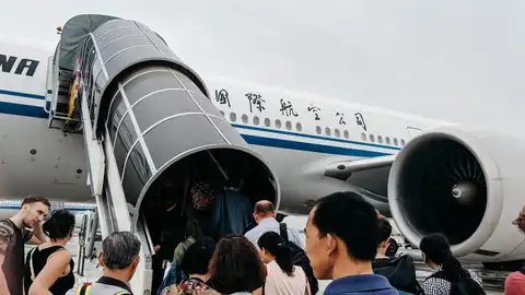 Pasajeros subiendo a un avión en China Pasajeros subiendo a un avión en China