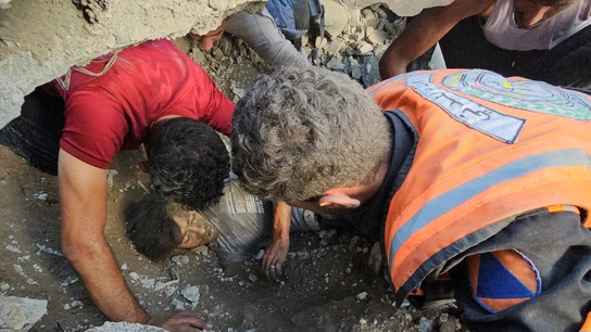 Palestinos trabajan en el rescate de una víctima en el lugar de los ataques israelíes contra el campo de refugiados de Yabalia Palestinos trabajan en el rescate de una víctima en el lugar de los ataques israelíes contra el campo de refugiados de Yabalia