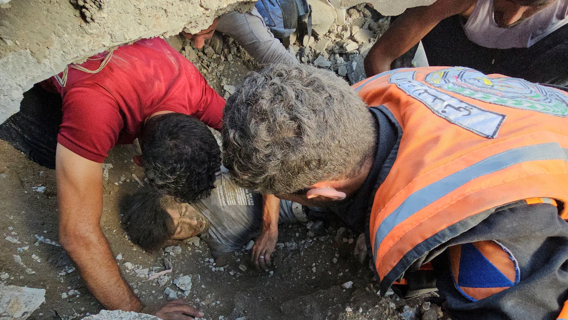 Palestinos trabajan en el rescate de una víctima en el lugar de los ataques israelíes contra el campo de refugiados de Yabalia