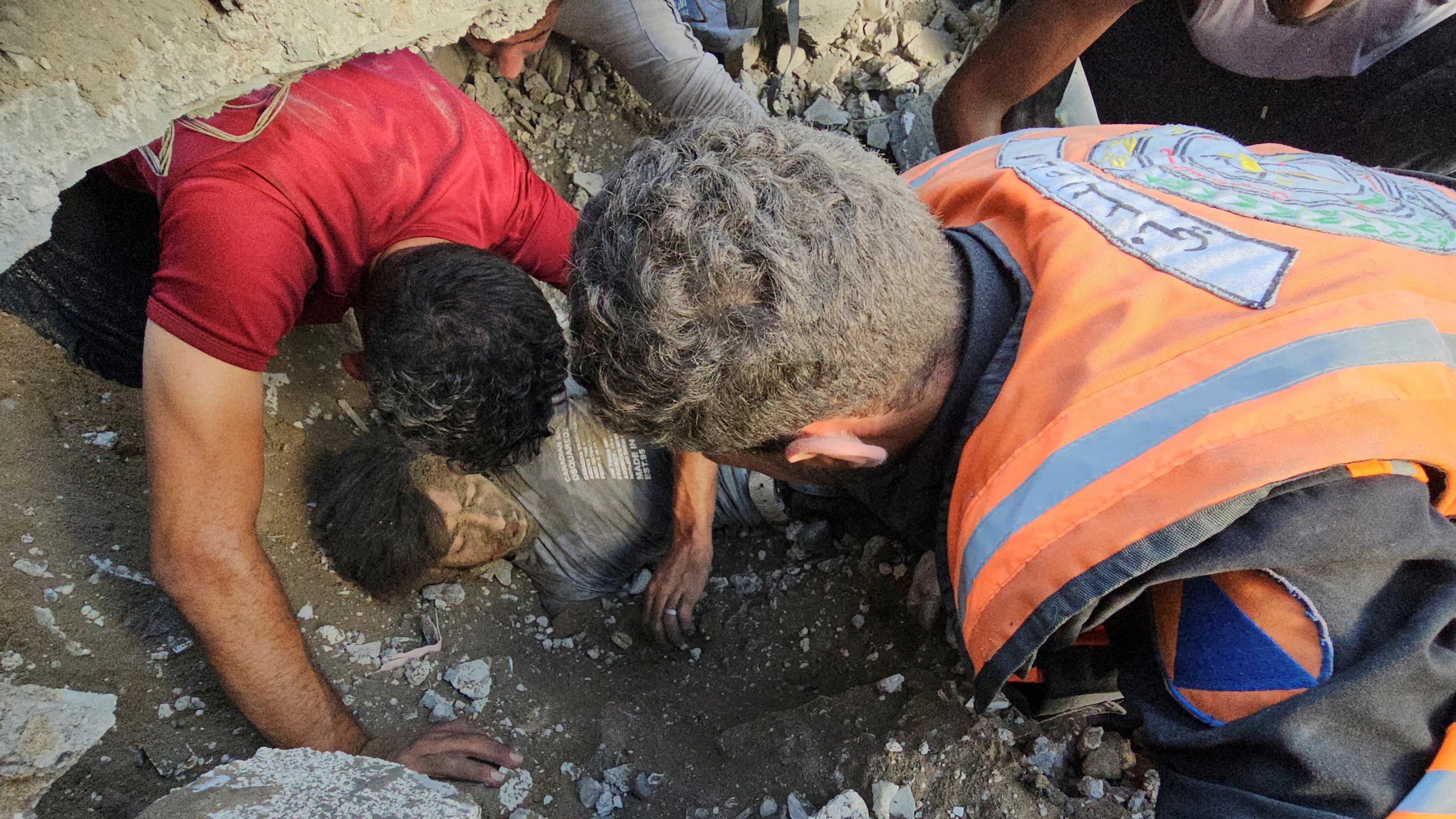 Palestinos trabajan en el rescate de una víctima en el lugar de los ataques israelíes contra el campo de refugiados de Yabalia