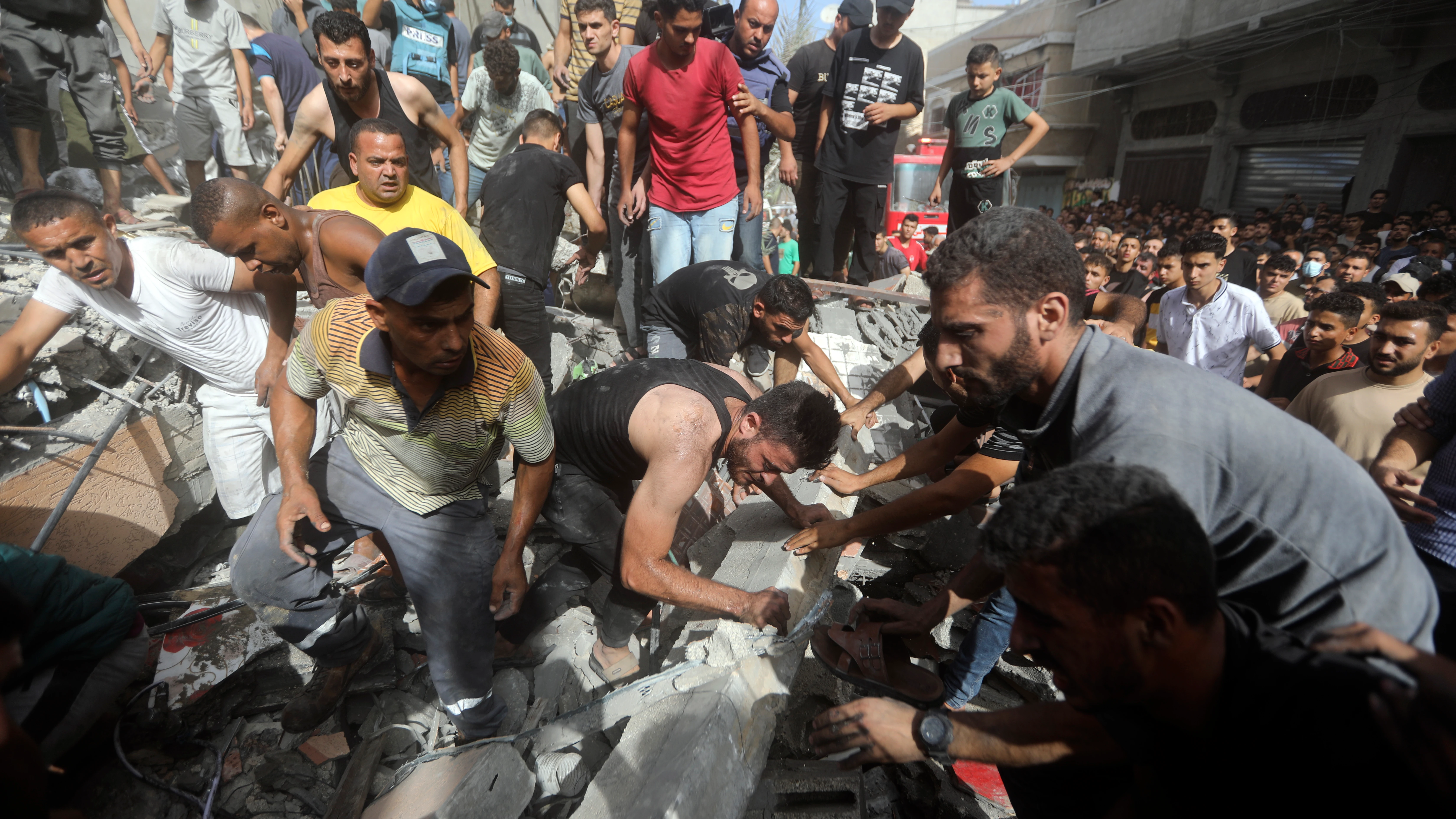 Palestinos intentan rescatar a personas atrapadas en un edificio derribado por ataques israelíes en la Franja de Gaza