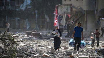Una familia palestina se abre paso entre los escombros de los edificios alcanzados en un bombardeo israelí sobre el barrio de Tel al-Hawa, en Ciudad de Gaza, el 30 de octubre.