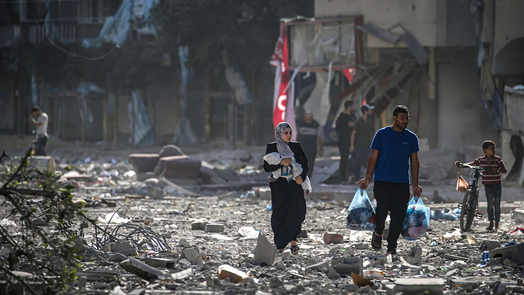 Una familia palestina se abre paso entre los escombros de los edificios alcanzados en un bombardeo israelí sobre el barrio de Tel al-Hawa, en Ciudad de Gaza, el 30 de octubre.