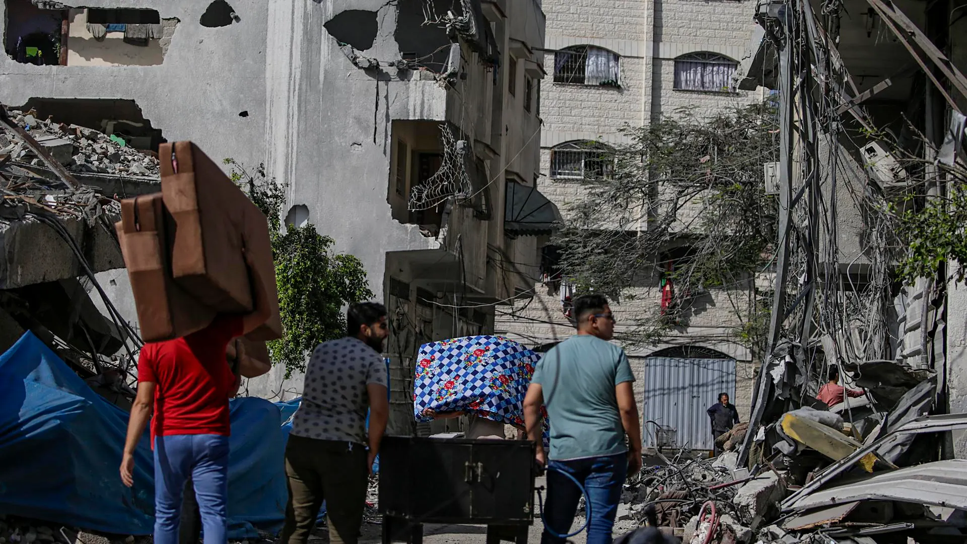 Ciudadanos cargan sus pertenencias mientras evacúan la ciudad de Gaza