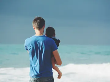 Un padre con un niño frente al mar Un padre con un niño frente al mar
