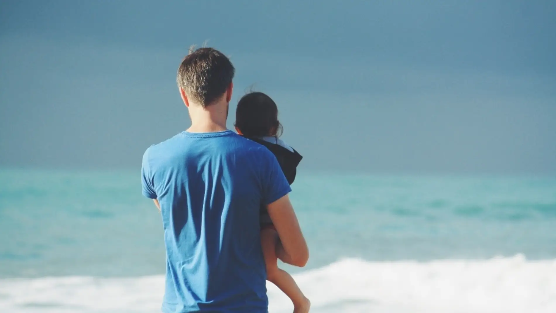 Un padre con un niño frente al mar