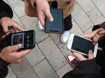 Imagen de archivo de unos jóvenes utilizando sus teléfonos móviles.