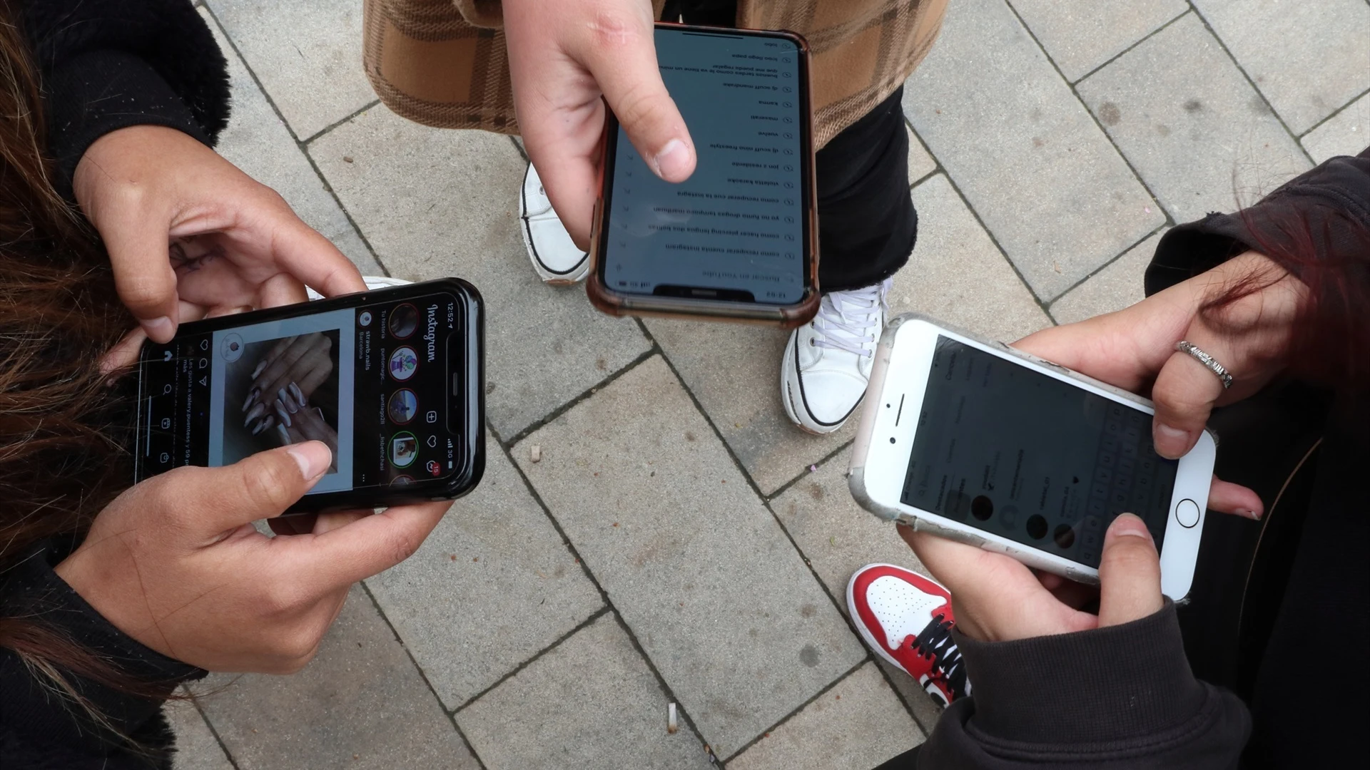 Imagen de archivo de unos jóvenes utilizando sus teléfonos móviles.