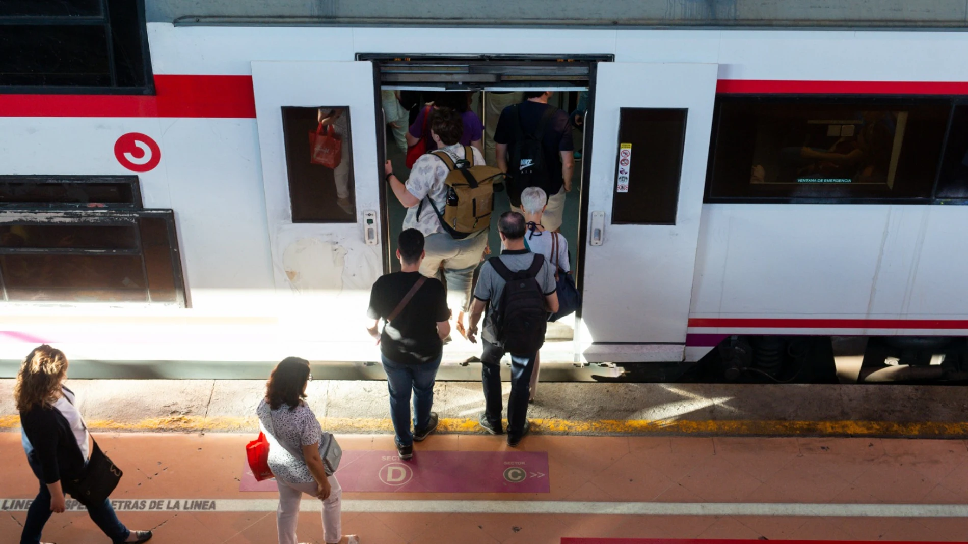 Varias personas a su entrada en un vagón de tren en la estación de Puerta de Atocha-Almudena Grandes.