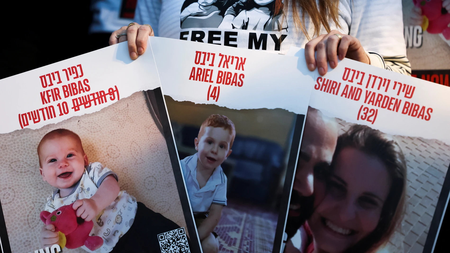 Una manifestante sostiene carteles pidiendo la liberación de los rehenes de Hamás Shiri Bibas y sus hijos Kfir y Ariel 