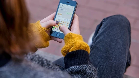 Adolescente con un teléfono móvil en mano. Adolescente con un teléfono móvil en mano.