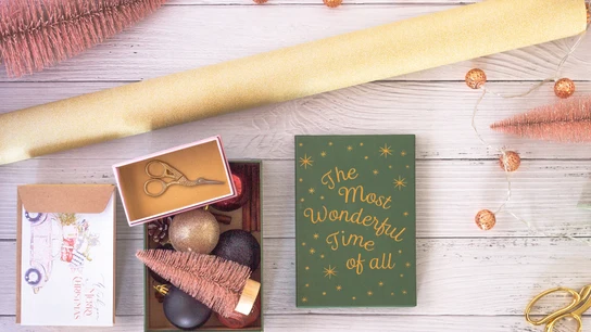 Mesa con papel y decoraciones para hacer una tarjeta de Navidad artesanal. Mesa con papel y decoraciones para hacer una tarjeta de Navidad artesanal.