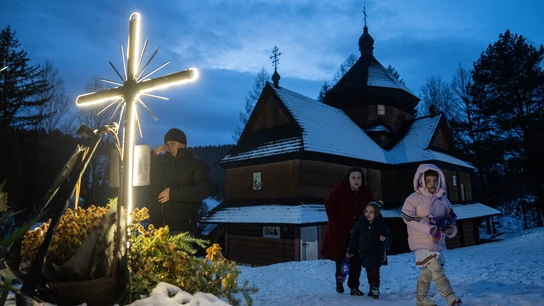 Una mujer camina con sus hijos después del servicio religioso de Navidad en la aldea de Kryvorivnia, Ucrania Una mujer camina con sus hijos después del servicio religioso de Navidad en la aldea de Kryvorivnia, Ucrania