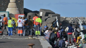 Trabajadores de la Cruz Roja al lado de uno de los cayucos que ha llegado al puerto de La Restinga, a 23 de octubre de 2023.