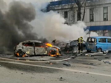 Bomberos rusos extinguiendo un coche en llamas después de un bombardeo en Belgorod