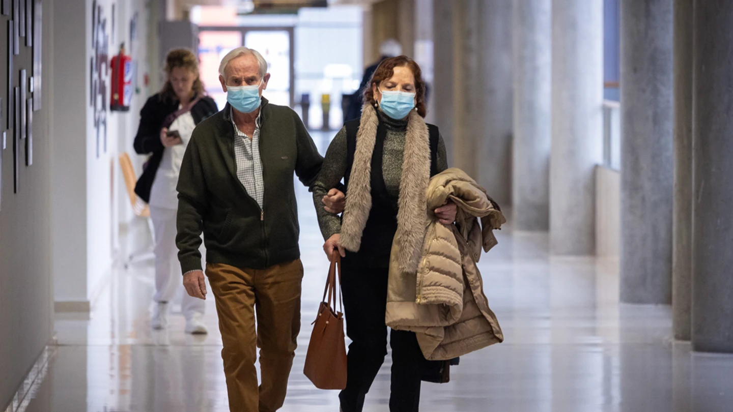 Dos personas con mascarillas Dos personas con mascarillas