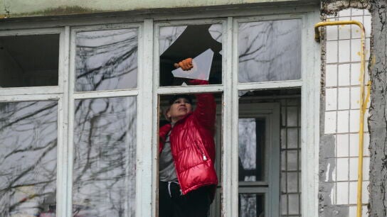 Una mujer retira cristales de una ventana tras un ataque con drones por parte del ej&eacute;rcito ruso en Odesa (Ucrania)