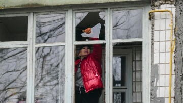 Una mujer retira cristales de una ventana tras un ataque con drones por parte del ejército ruso en Odesa (Ucrania)