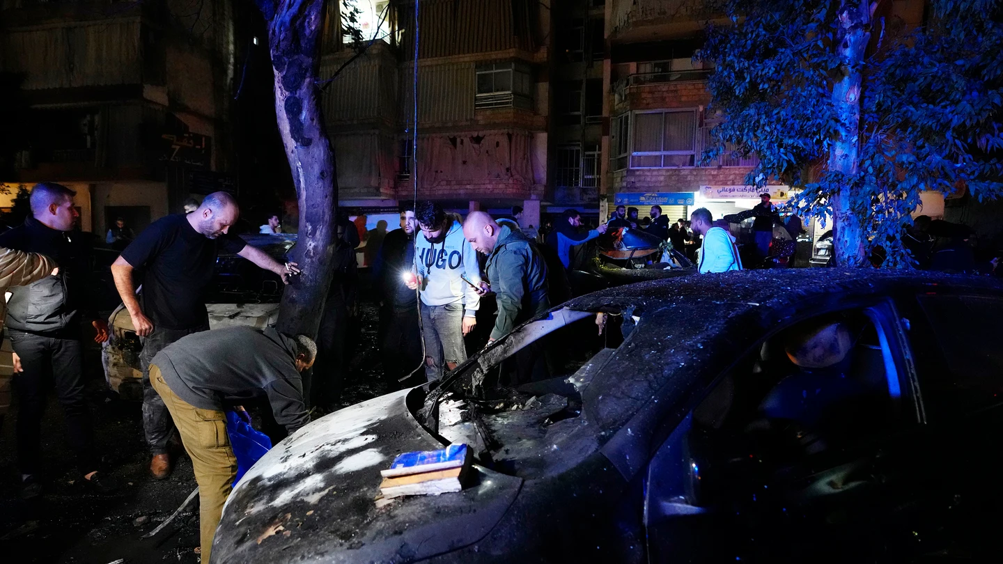 Personas inspeccionando partes de cuerpos tras una explosión masiva en el suburbio sur de Beirut, Líbano Personas inspeccionando partes de cuerpos tras una explosión masiva en el suburbio sur de Beirut, Líbano