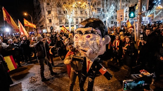 Uno de los manifestantes golpea el muñeco que simula ser Pedro Sánchez en la protesta del 31 de diciembre en la calle Ferraz. Uno de los manifestantes golpea el muñeco que simula ser Pedro Sánchez en la protesta del 31 de diciembre en la calle Ferraz.