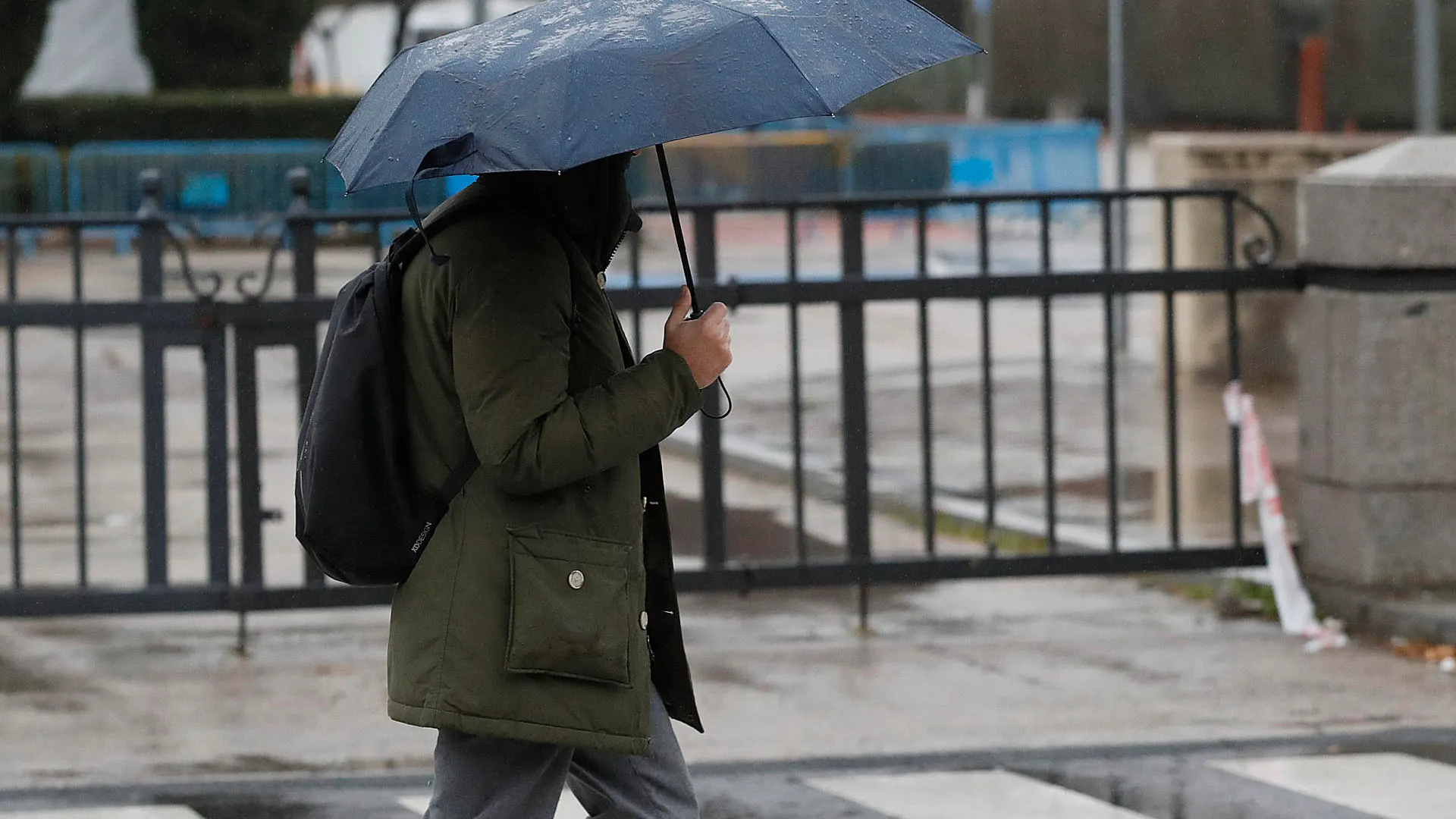 Imagen de archivo de una persona paseando bajo la lluvia con un paraguas.