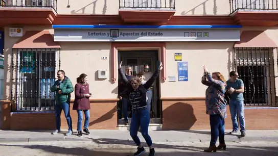 Una mujer salta de alegría en la puerta de la administración tras tocar parte del tercer premio, 18918, de la Lotería del Niño en Guillena. Una mujer salta de alegría en la puerta de la administración tras tocar parte del tercer premio, 18918, de la Lotería del Niño en Guillena.
