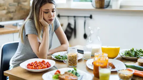 Mujer sin apetito frente a la comida Mujer sin apetito frente a la comida