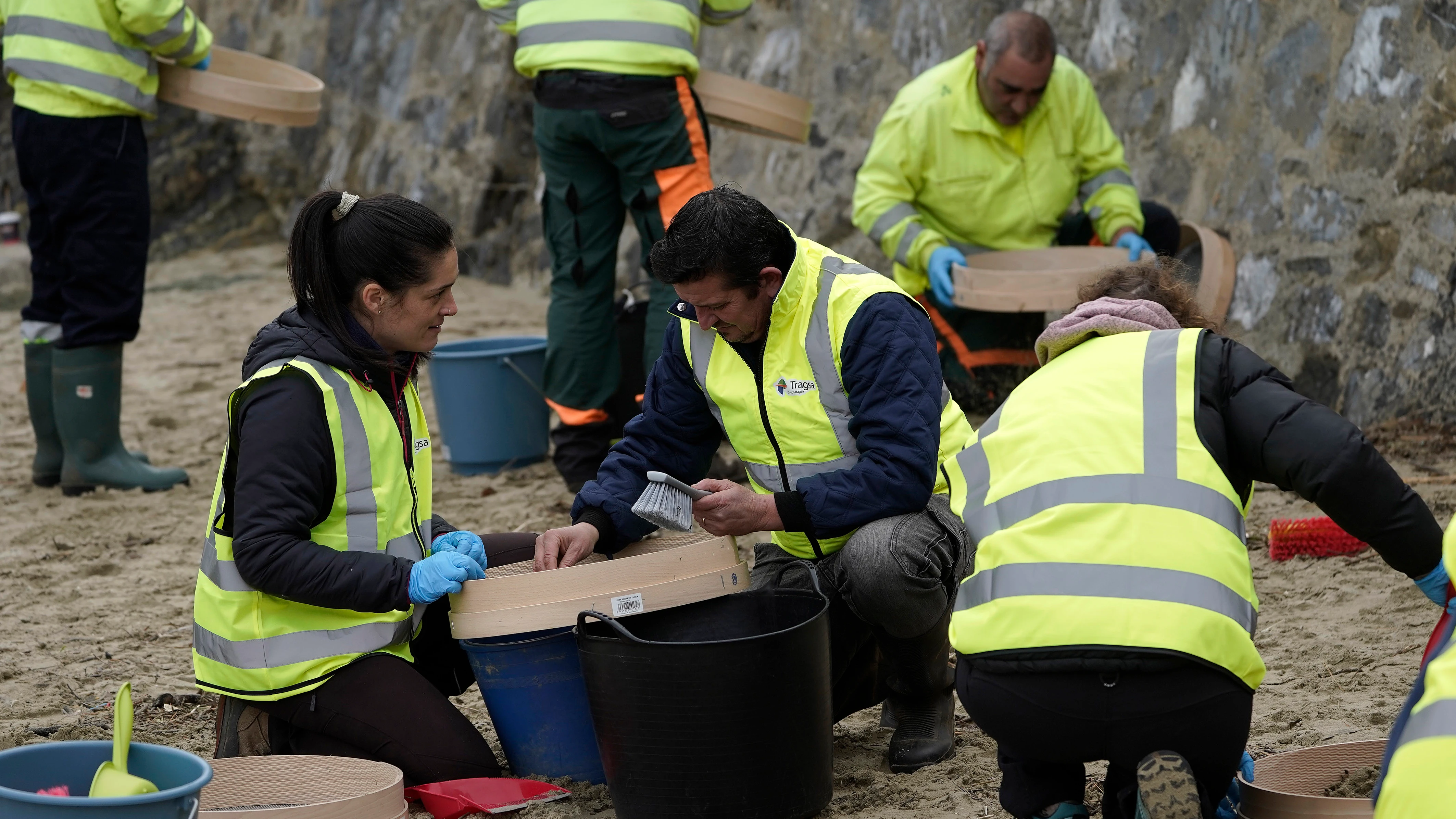 Operarios retiran los pellets o bolitas para fabricar plástico que aparecen en las playas de Asturias