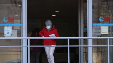 Una mujer con una mascarilla en la cara a su salida de un centro de salud