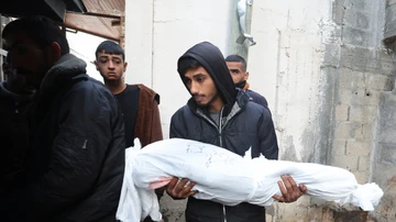 Un hombre lleva el cuerpo de una víctima palestina muerta en un ataque israelí en el hospital Abu Yousef al-Najjar, en Rafah, en el sur de la Franja de Gaza, este 12 de enero.