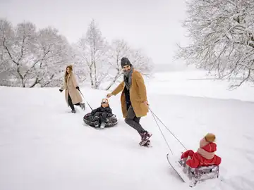 Familia con trineos en la nieve Familia con trineos en la nieve